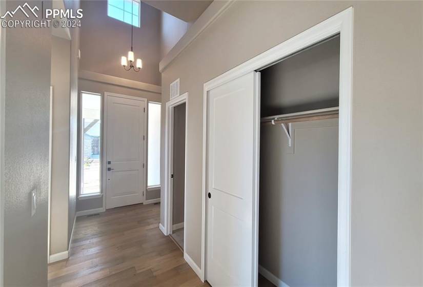 Inviting Entryway with engineered wood flooring and a coat closet!