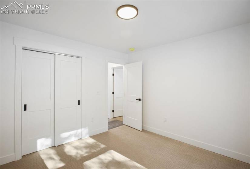 Unfurnished bedroom with a closet and light carpet