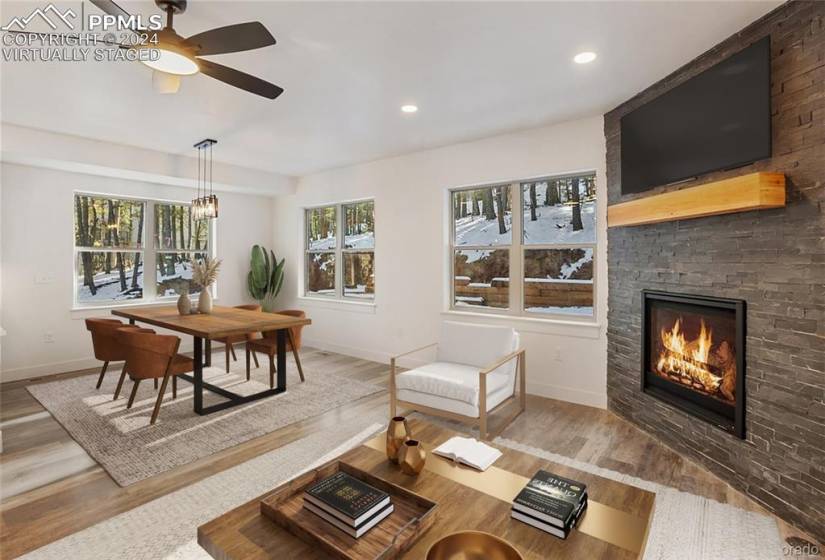 Virtually staged: Living room featuring ceiling fan, LVP flooring, and a stone fireplace