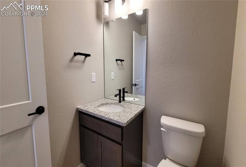Powder Room, located on the main level with granite countertop, cabinet, and engineered wood flooring!