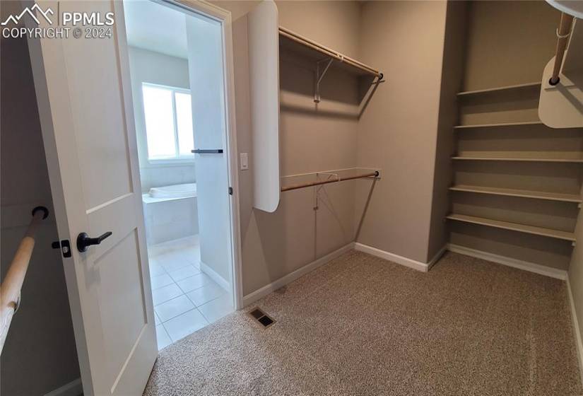 Primary Walk-In Closet with Wood Shelving and Rods!