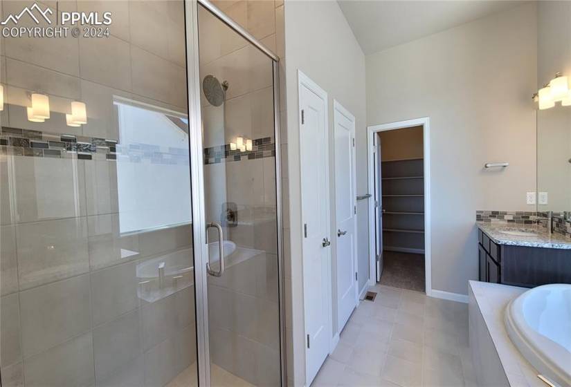 Primary shower with bench and tile surround, there is a linen closet as well!