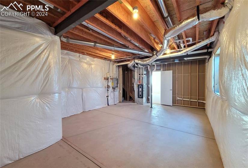 Utility/Storage room with a tankless water heater, 96% energy efficient furnace with a variable speed motor, sealed ducts, pex water piping, and a sprinkler stub in this energy rated home!