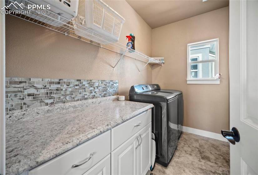 Laundry room is conveniently located upstairs and boasts counter and cabinet space.