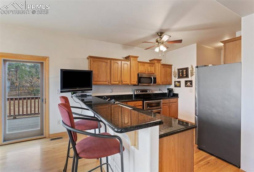 Kitchen with raised bar for relaxation also highlights wood floors on main level