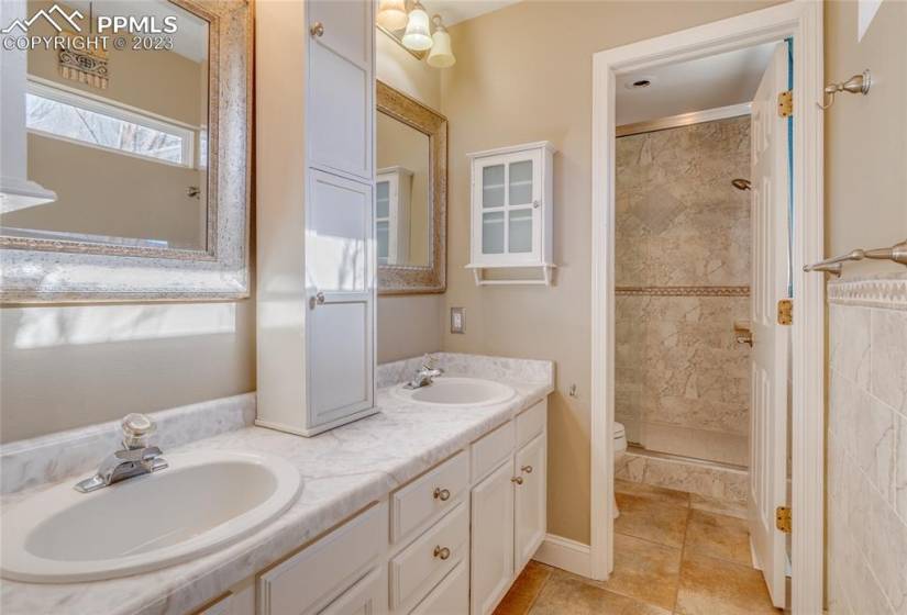 Master bathroom with double vanity, tile floors and tile shower surround... shower has dual shower heads.