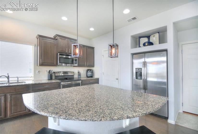 Large center island in the kitchen and stainless steel appliances.