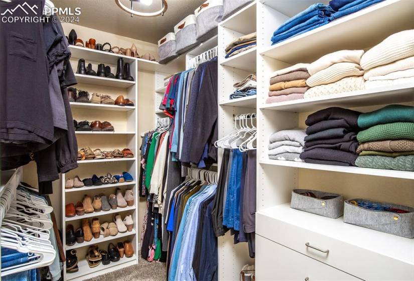 Walk-in closet w/new custom-built system with hidden laundry bins and custom drawers.