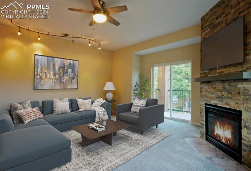 Living room featuring a fireplace, ceiling fan, light carpet, and rail lighting, virtually staged