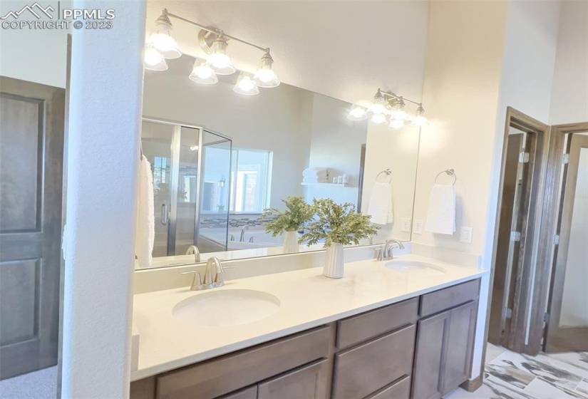 Double vanity in master bath with quartz countertops and raised vanity cabinets.