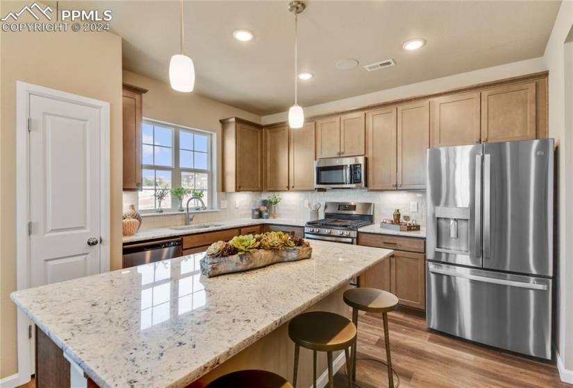Gourmet kitchen with center island, quartz counters, and stainless appliances