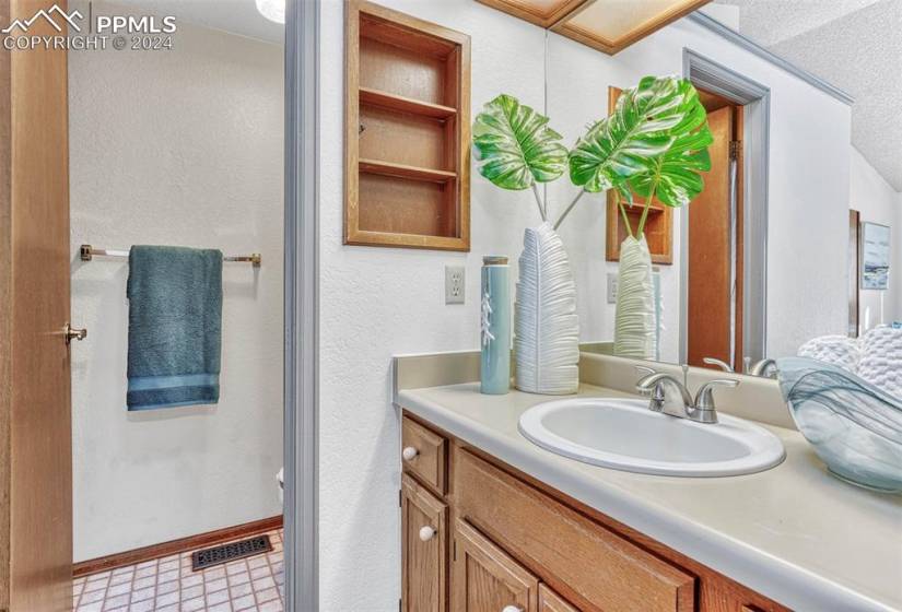 The Primary Bathroom offers a walk-in closet, a skylight, vanity, mirror, and tiled shower.