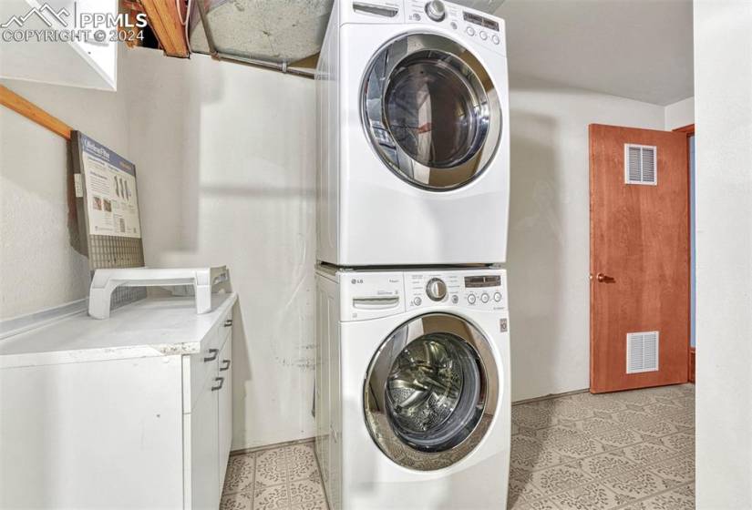 Basement Laundry Room with storage cabinet and washer/dryer that stays.