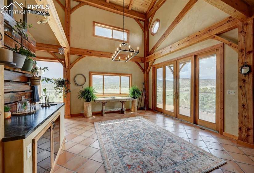 Sun Room featuring Double Sliding Doors to Back Deck with Mountain/Valley Views and French Doors connecting Primary Bedroom to Sunroom.