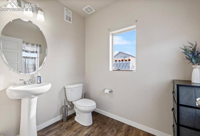 Powder Bathroom with pedestal sink and round mirror off the Kitchen
