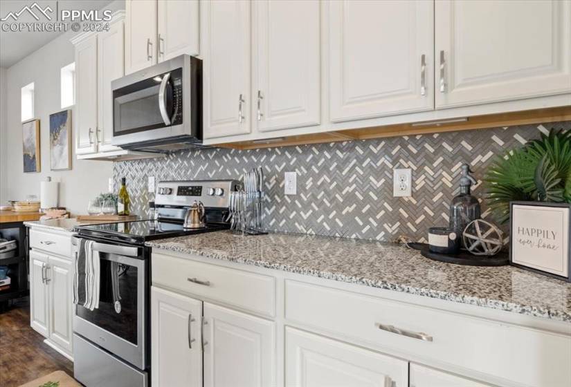 White cabinets with granite countertops and tile baxksplash