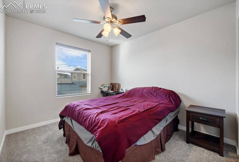 Upper Level Bedroom #2 with neutral carpet and lighted ceiling fan