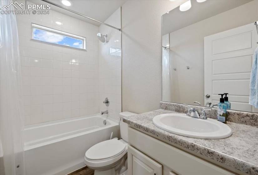 Upper Level Hall Bathroom with vanity, mirror, and tiled tub/shower