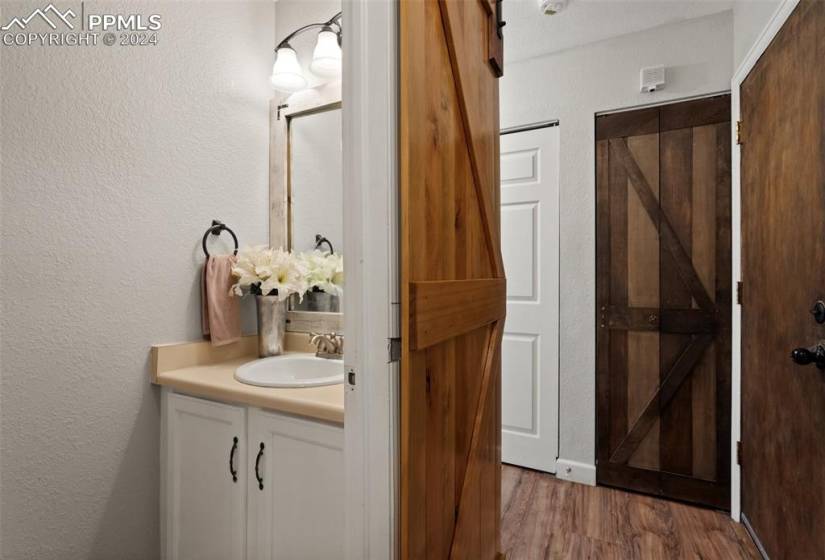 Main level Powder Room is around the corner from the kitchen. The barn door completes the comfy, cozy feel.