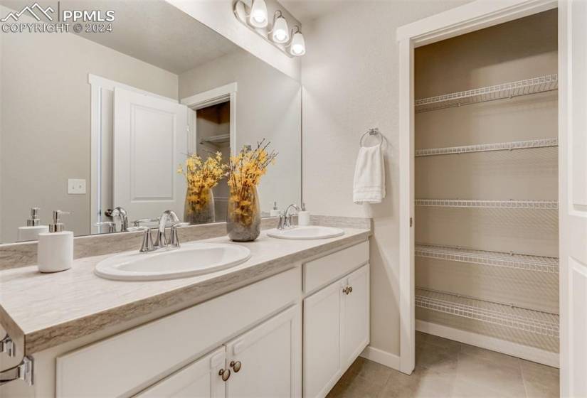 Dual vanities and large storage closet in the bathroom.