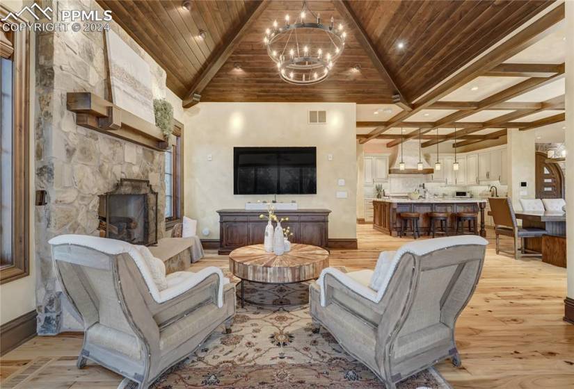 Cozy hearth room located off kitchen with gorgeous wood tongue and groove ceiling and fireplace with stone surround