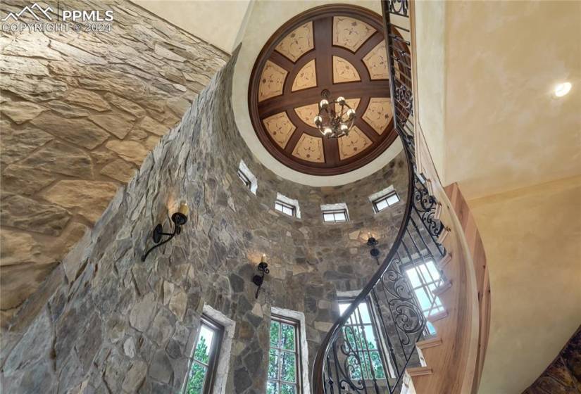 Stunning circular staircase spans all 3 levels, elliptical ceiling with motorized chandelier, hand painted gold leafing