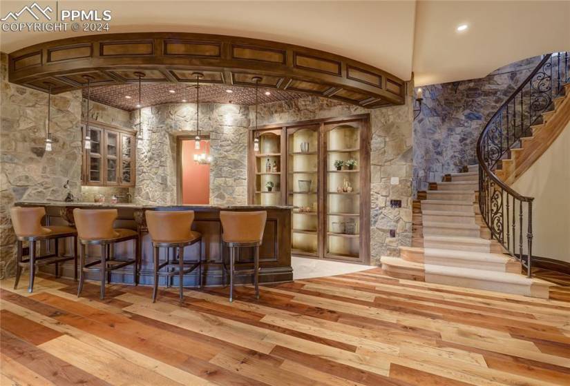Wet bar with sub-zero fridge and ice maker and Bosch dishwasher; copper tile backsplash and faux tin ceiling. The shelving opens up to a safe room with a Fort Know vault door, and wine celler is to the left