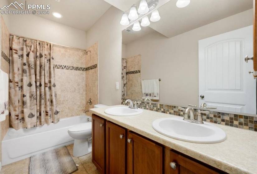 Basement Bathroom with vanity, mirror, and tiled tub/shower.