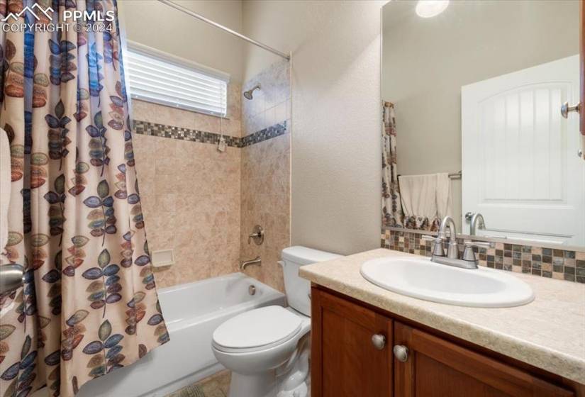 Main level Hall Bathroom with vanity, mirror, and tiled tub/shower.