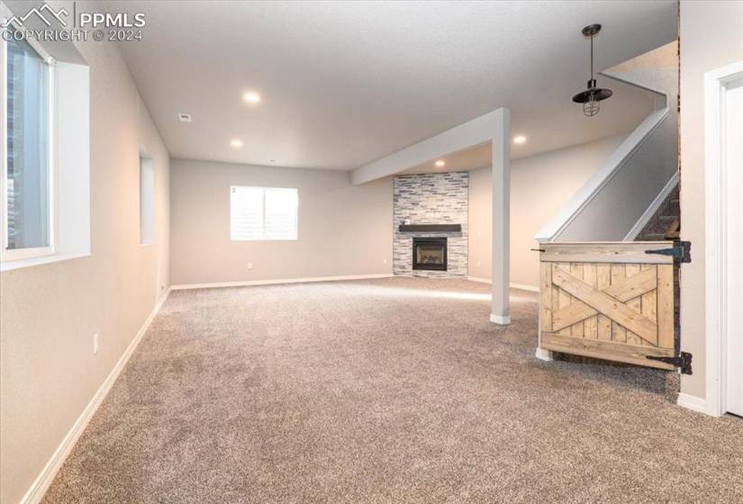 Downstairs family room featuring a fireplace and carpet floors