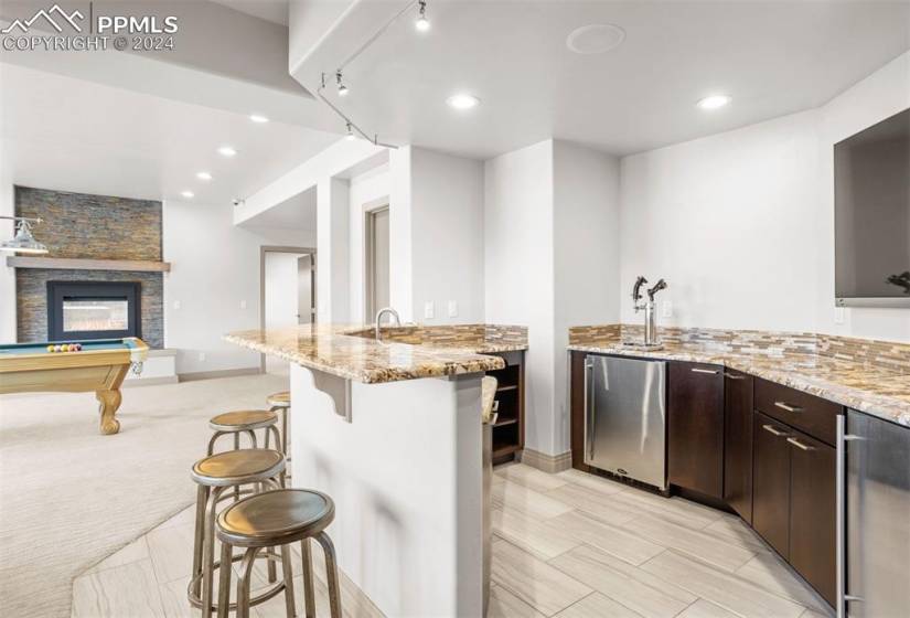 Granite wet bar and double kegerator with fighter jet taps.