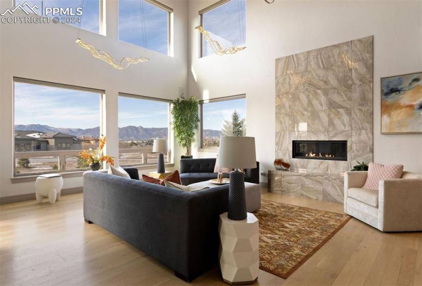 The great room offers amazing views, a cosmopolitan fireplace, and white oak floors.