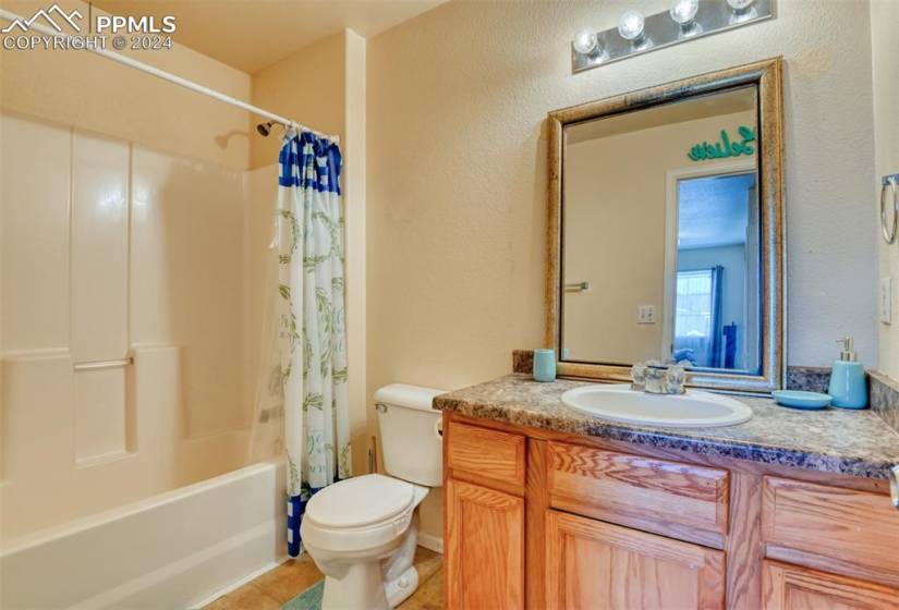 Upstairs Full bathroom with shower / bathtub combination with curtain, toilet, large vanity, and tile floors