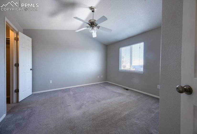 Upper Level Primary Owner's Suite with lighted ceiling fan, adjoining bathroom, and walk in closet