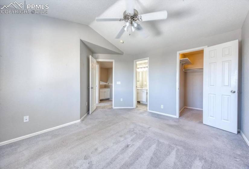 Upper Level Owner's Suite with neutral carpet, a lighted ceiling fan, walk in closet, and adjoining Full Bathroom