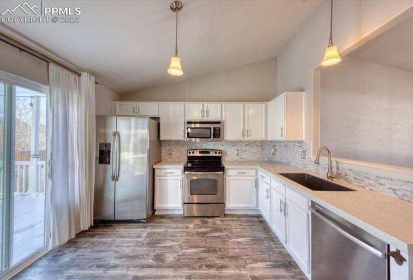 Stainless steel appliances include a French door refrigerator, smooth top range oven, and built-in microwave.