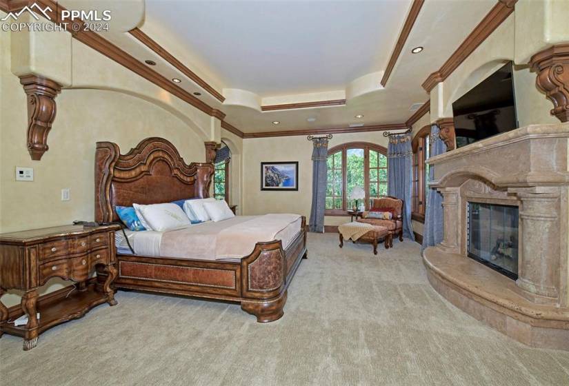 Bedroom featuring light carpet, a raised ceiling, and ornamental molding