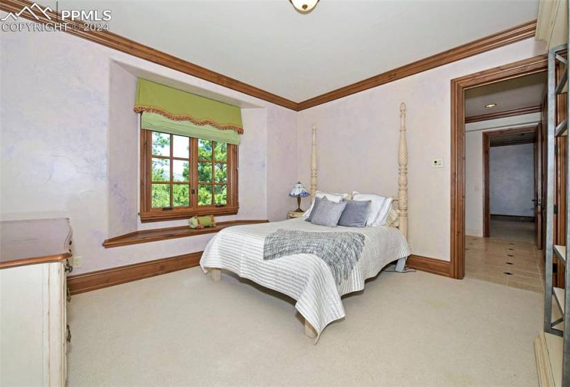 Bedroom with crown molding and light carpet