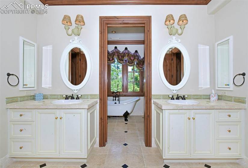 Bathroom featuring dual vanity, a bath to relax in, ornamental molding, and tile flooring
