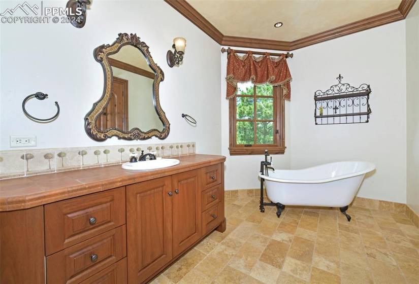 Bathroom featuring crown molding, vanity, tile flooring, and a bath to relax in