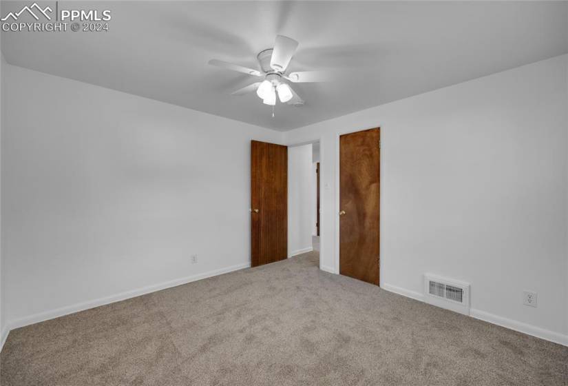 Unfurnished bedroom featuring a closet, ceiling fan, and light colored carpet