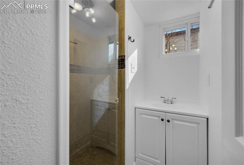 Bathroom with a shower with door and vanity