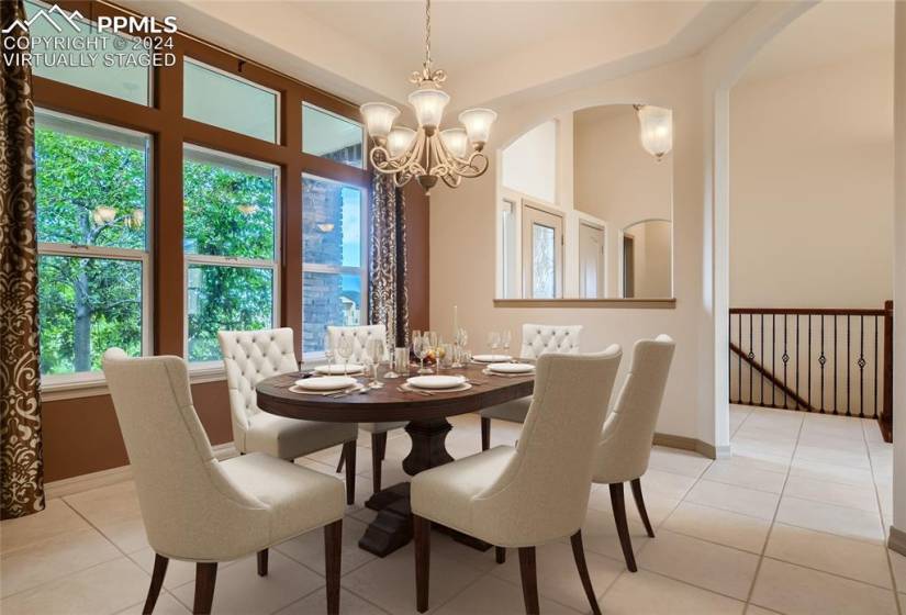 Virtually staged dining room with wall-to-wall windows and butler pantry to kitchen.