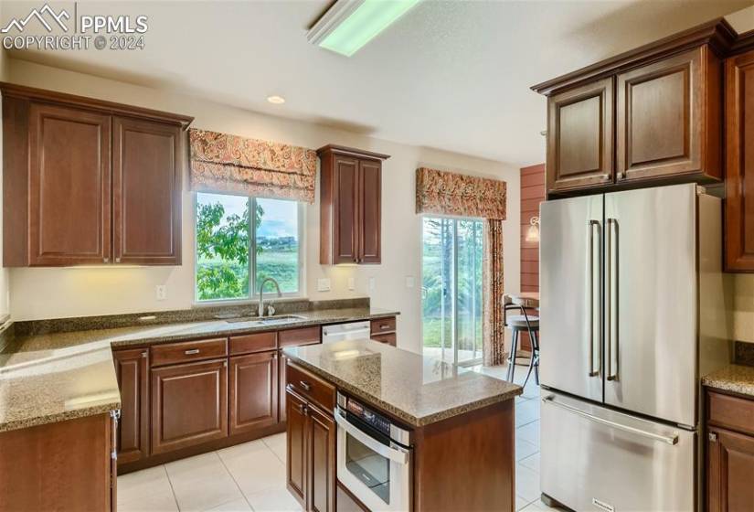 Gourmet kitchen with granite, stainless appliances, double ovens, upgraded cabinetry, bar, and island.