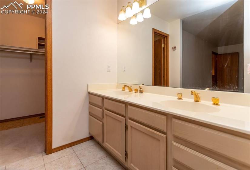 Bathroom featuring tile flooring, double sink, and vanity with extensive cabinet space.
