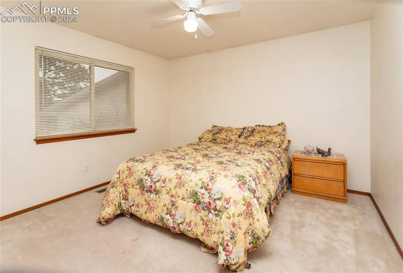 Carpeted bedroom featuring ceiling fan.