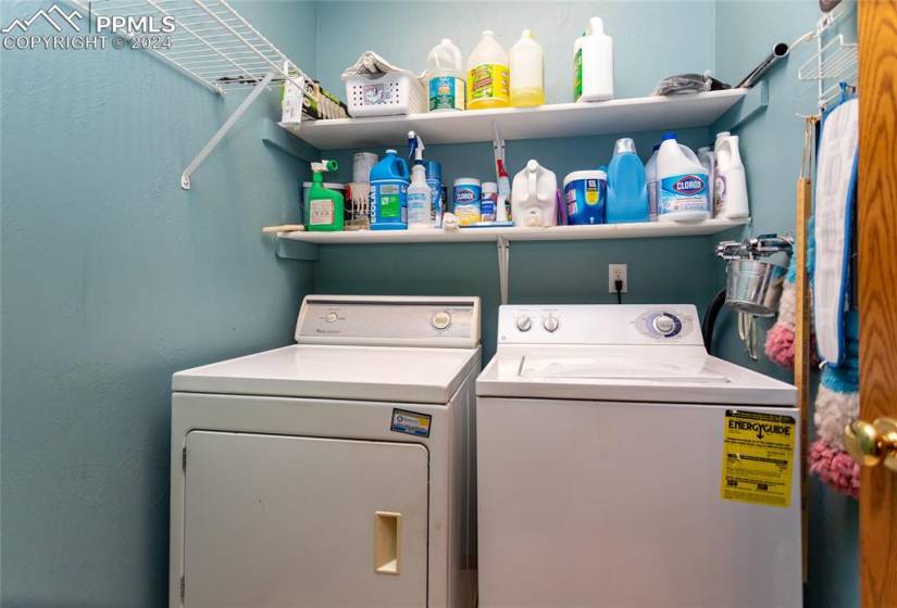 Washroom with washer and clothes dryer.