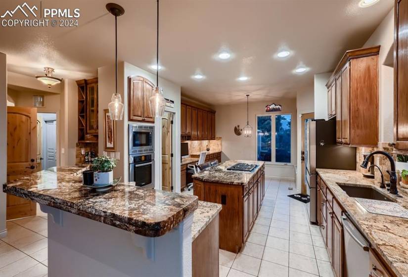 Kitchen featuring a kitchen island, hanging light fixtures, tasteful backsplash, sink, and stainless steel appliances
