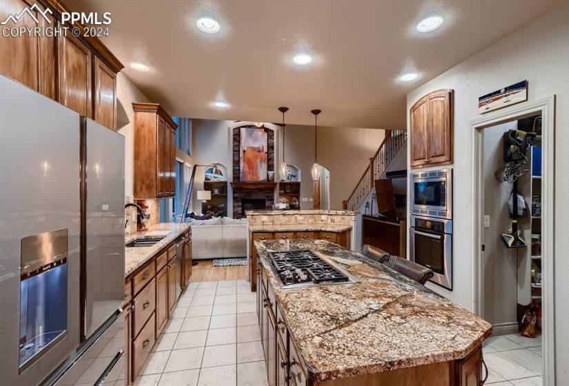 Kitchen with pendant lighting, appliances with stainless steel finishes, light tile floors, and a kitchen island