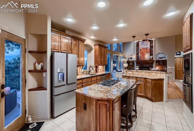 Kitchen with a kitchen island, granite countertops, stainless steel appliances, and pendant lighting.